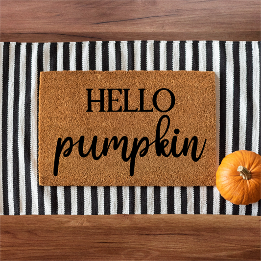 Doormat with 'HELLO pumpkin' text on a striped background with a small pumpkin.