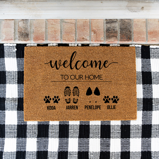 Doormat with 'welcome to our home' text and pet names on a checkered background