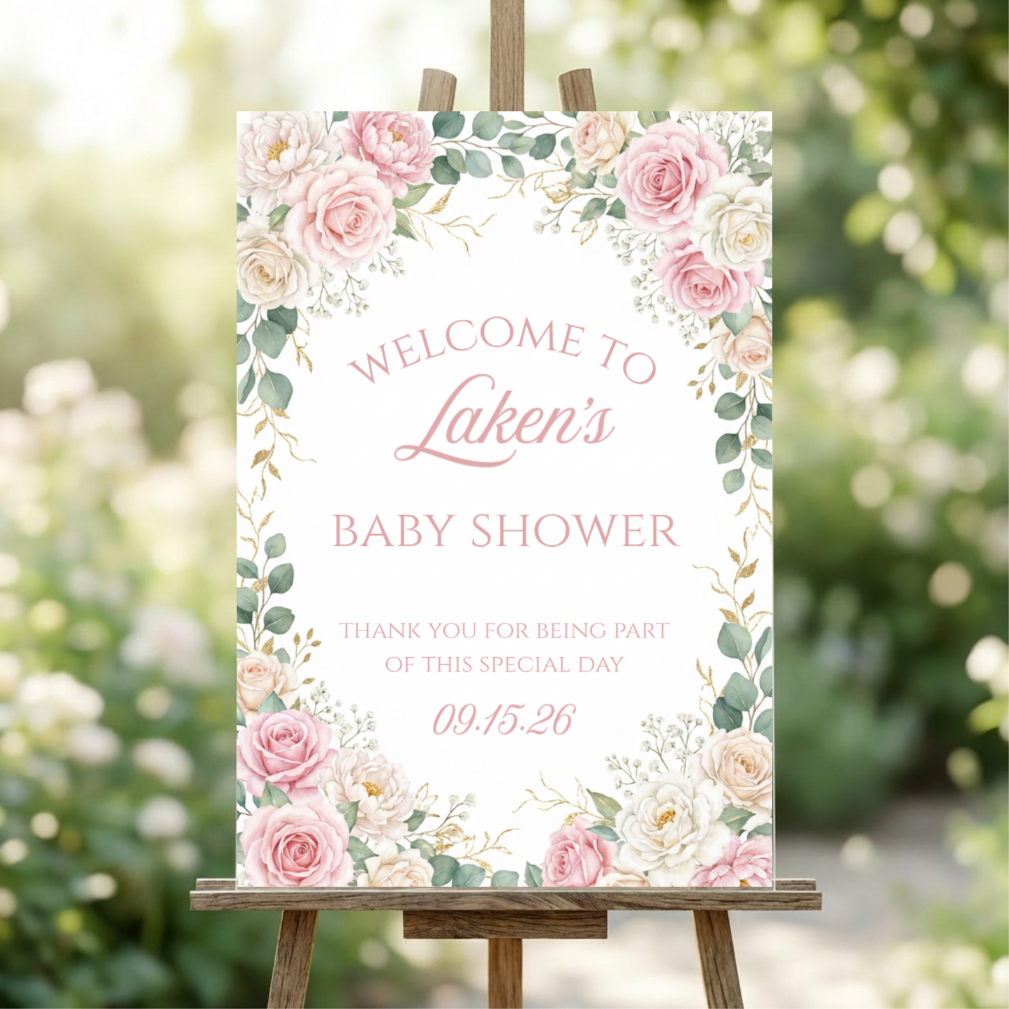Baby shower welcome sign with floral design on an easel outdoors.